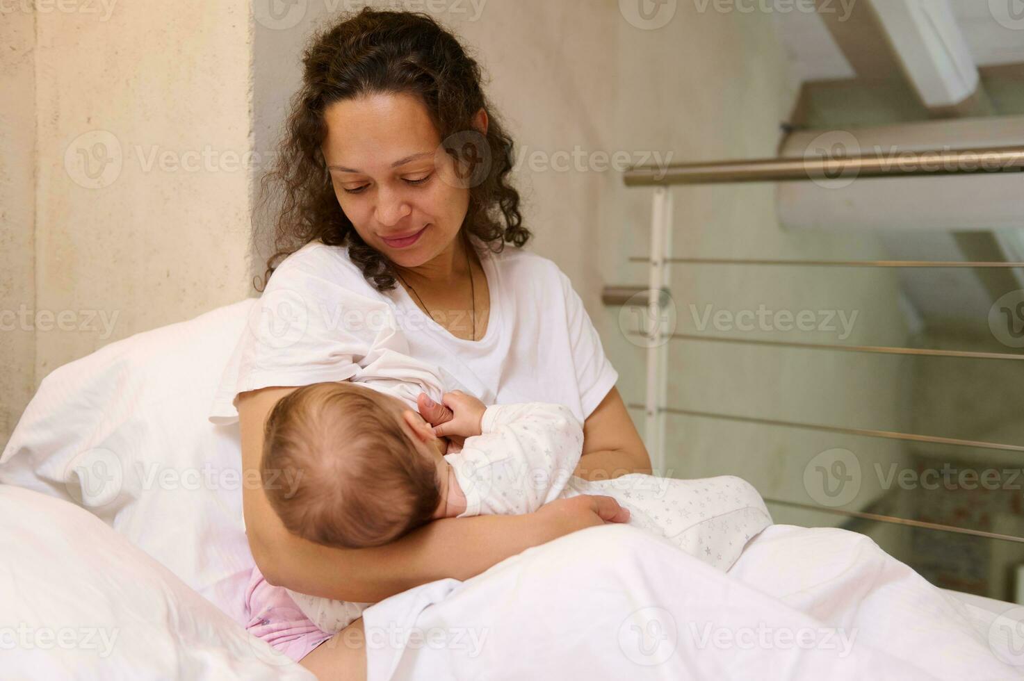 Beautiful loving Latin American mother breastfeeding her baby. Maternity leave and infancy concept. Copy ads space photo