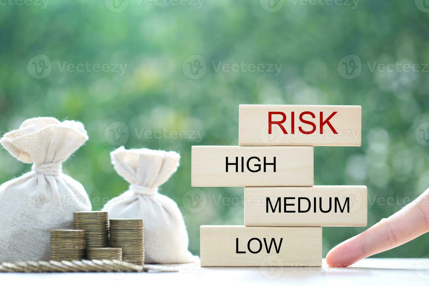 Money bag and wood block on natural green background, Business investment and Risk management concept.Financial risk assessment photo