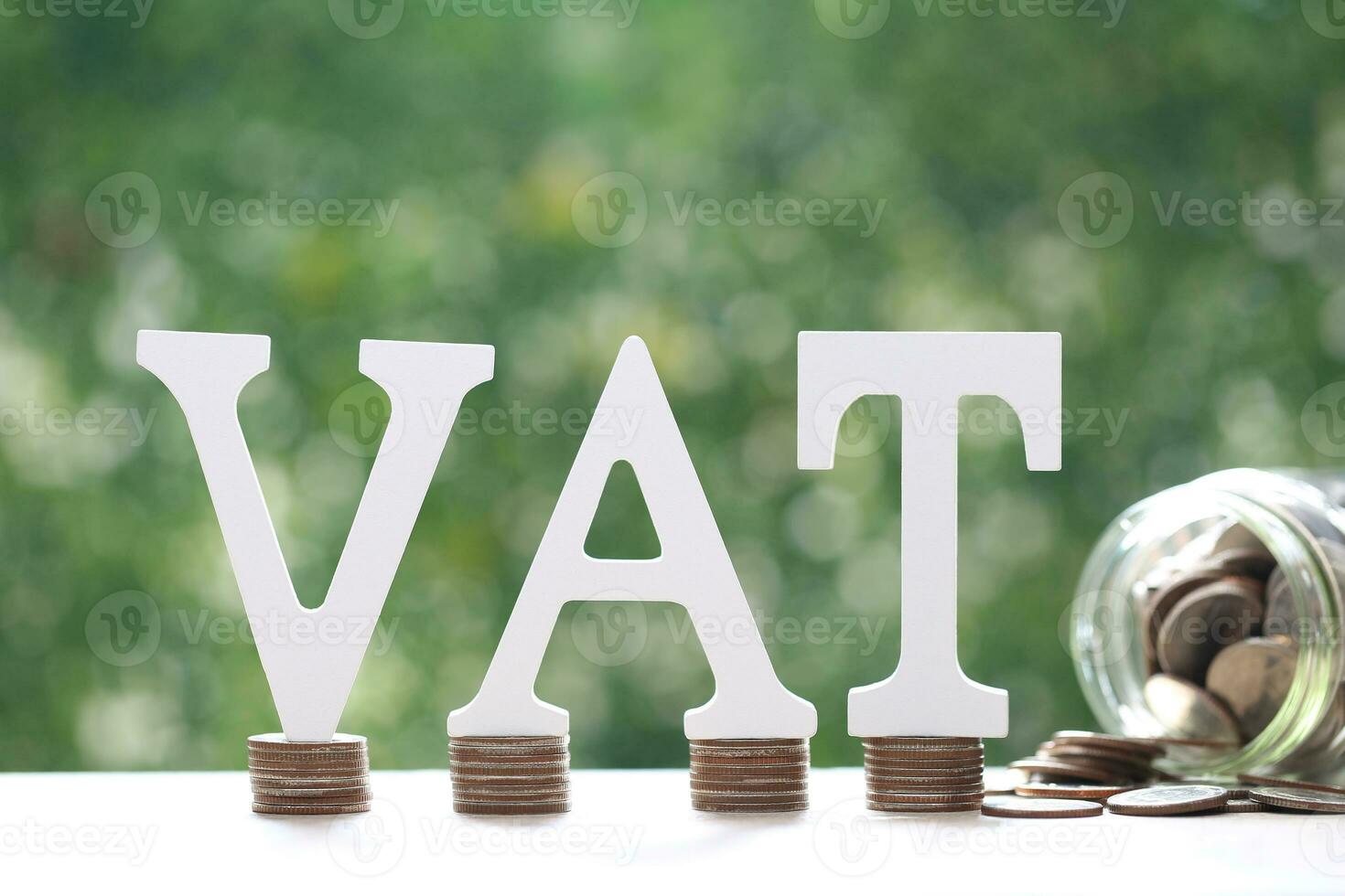 Tax wooden text and coins money in glass bottle on natural green background,Business investment and Property tax concept photo