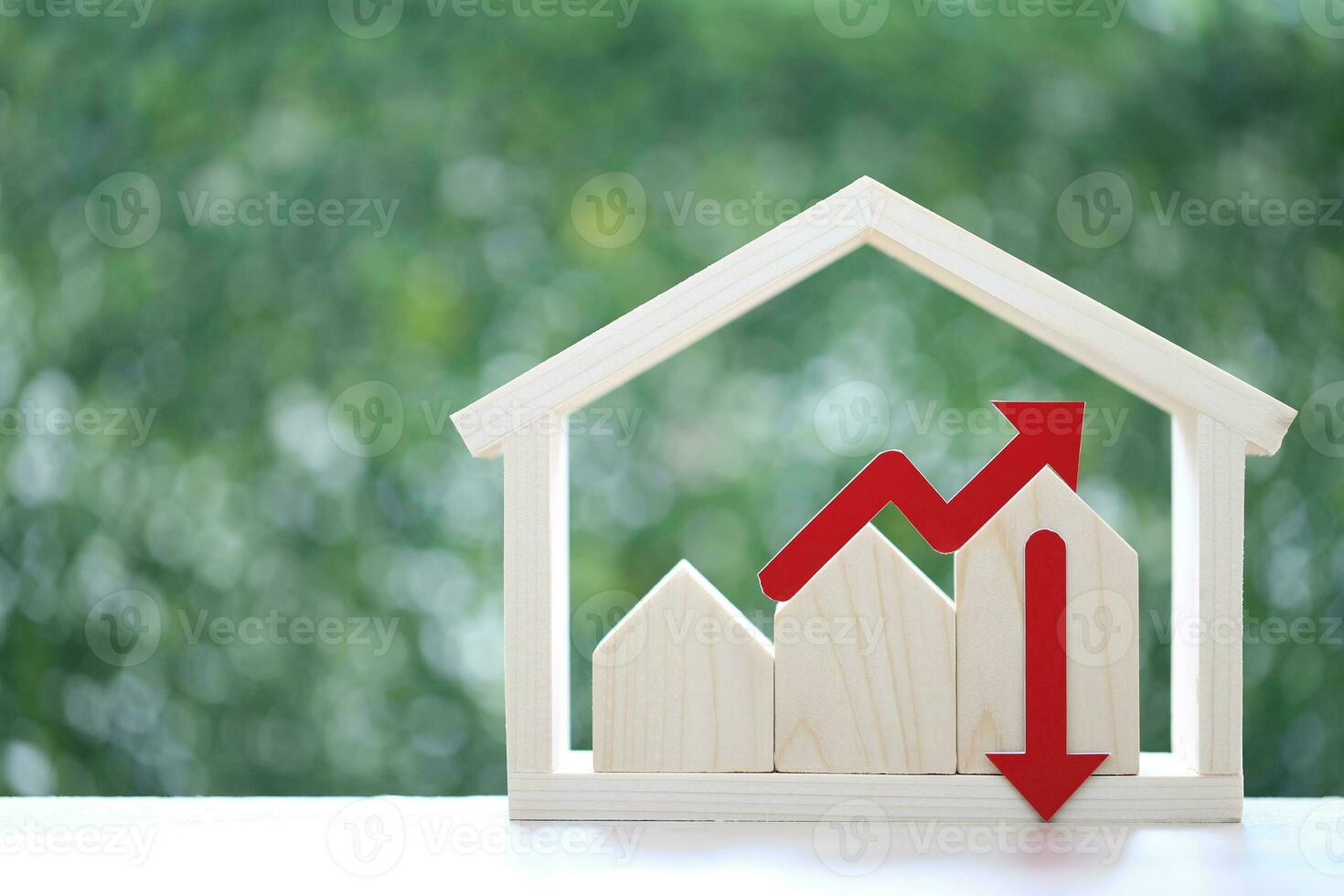 Model house and red arrow graph on natural green background,Business investment and real estate concept photo