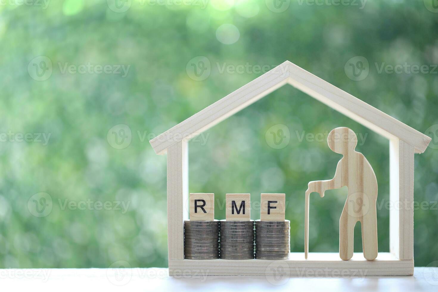RMF - Retirement Mutual Fund,Senior with RMF word on stack of coins money in model house on natural green background, Save money for prepare in future and pension retirement concept photo