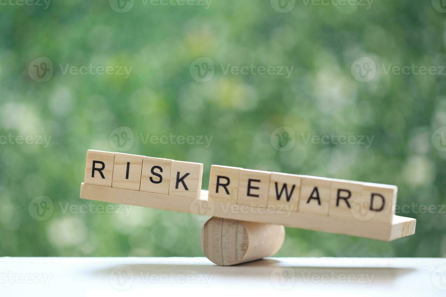 Wording risk and Reward on wood block on natural green background, Business investment and Risk management concept.Financial risk assessment photo