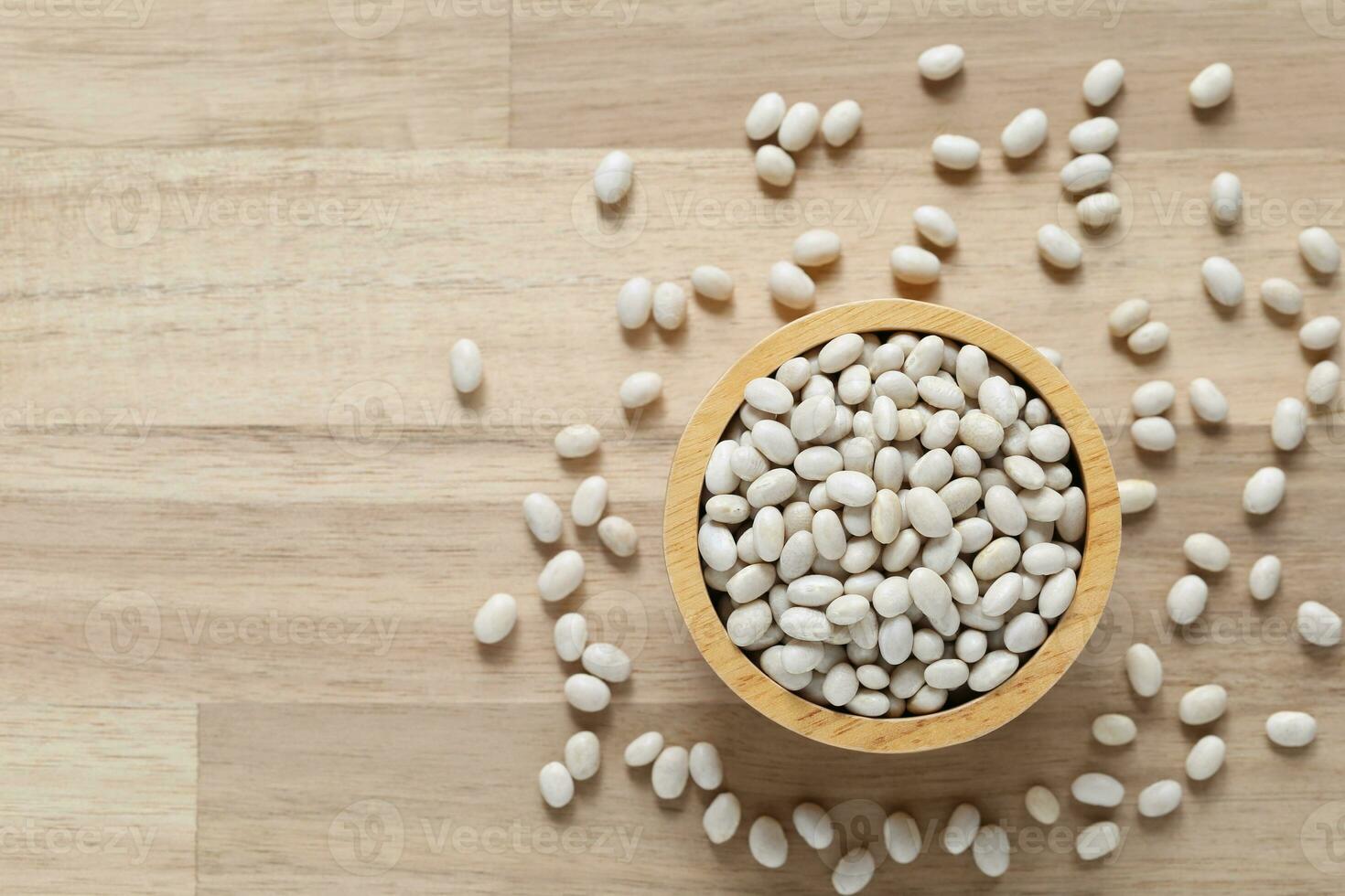 Top view of white beans in a bowl on wooder background, Healthy eating concept photo