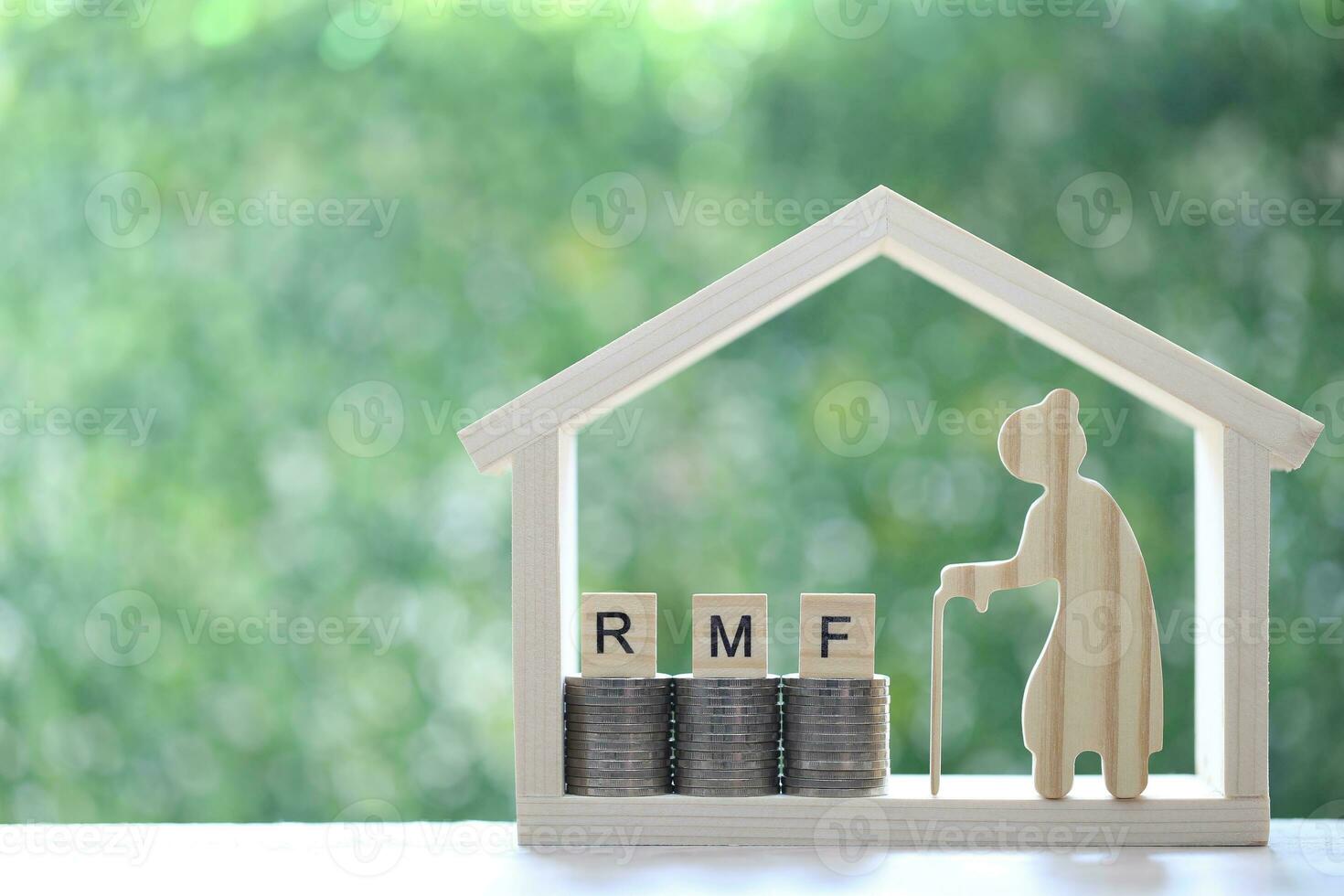 RMF - Retirement Mutual Fund,Senior with RMF word on stack of coins money in model house on natural green background, Save money for prepare in future and pension retirement concept photo