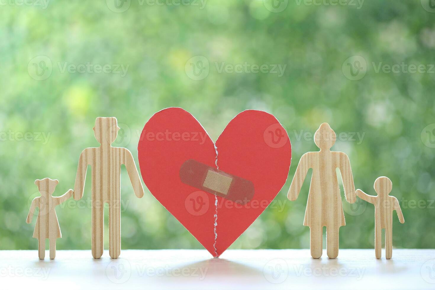 Divorce lawyer Or Attorney, Broken red heart with husband and wife splitting children on natural green background,Joint child custody and alimony concept. photo