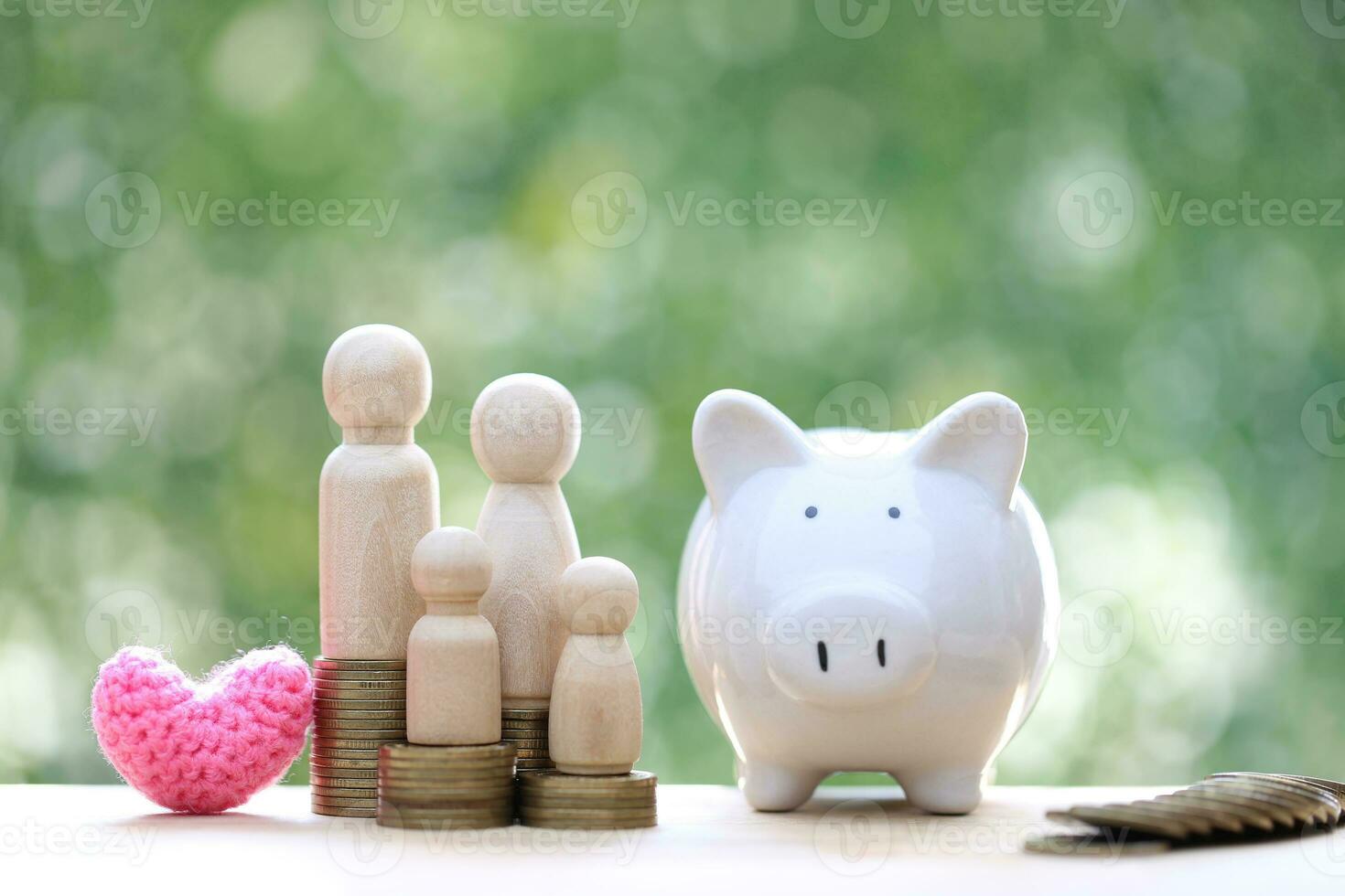 Model family with piggy bank and stack of coins money on natural green background,Save money for prepare in future and family finance concept photo