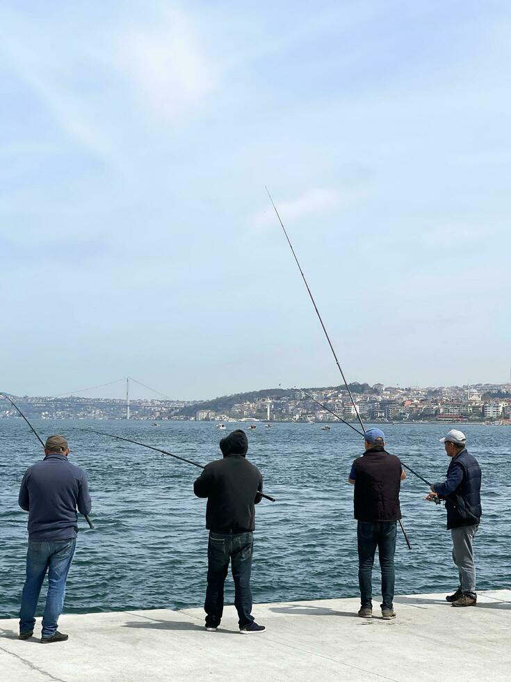 15 de abril 2023 - Estanbul, Turquía - pescadores en el frente al mar foto