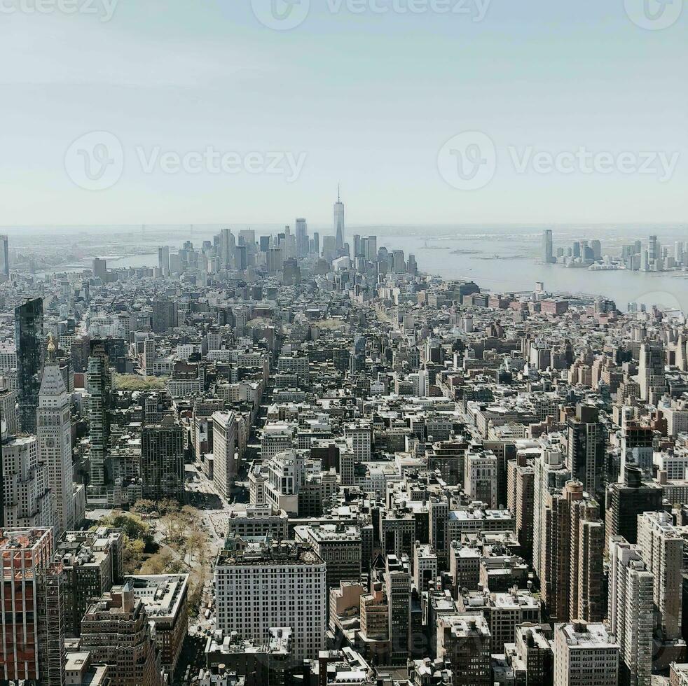 Aerial view of a dense urban New york cityscape with skyscrapers under a clear sky. photo