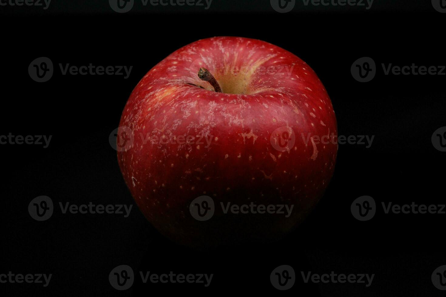 bright, vividly colored red apple on a black background during a studio photo session in the winter of 2023