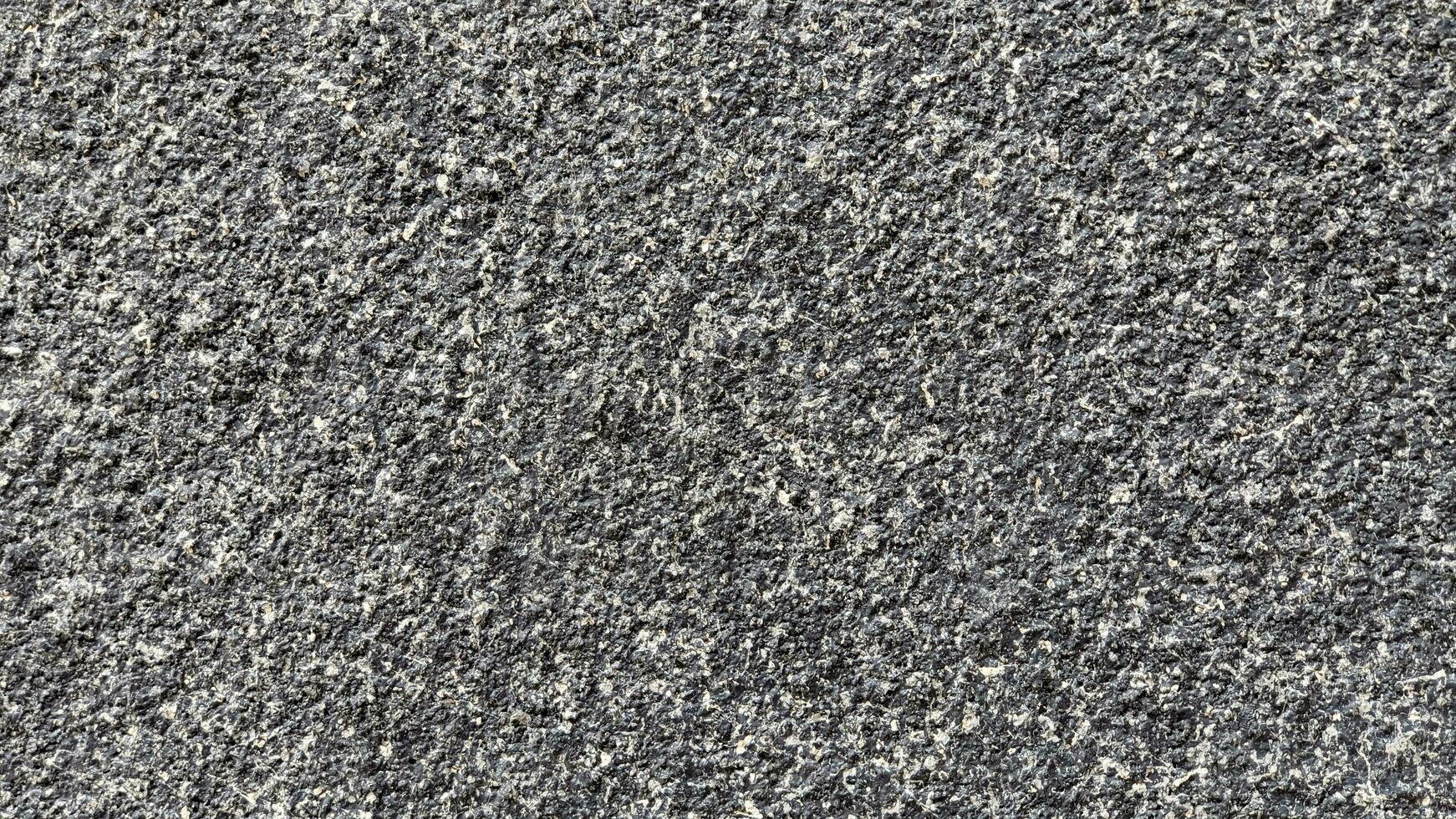 The surface of the concrete wall is covered with small gray pebbles. photo