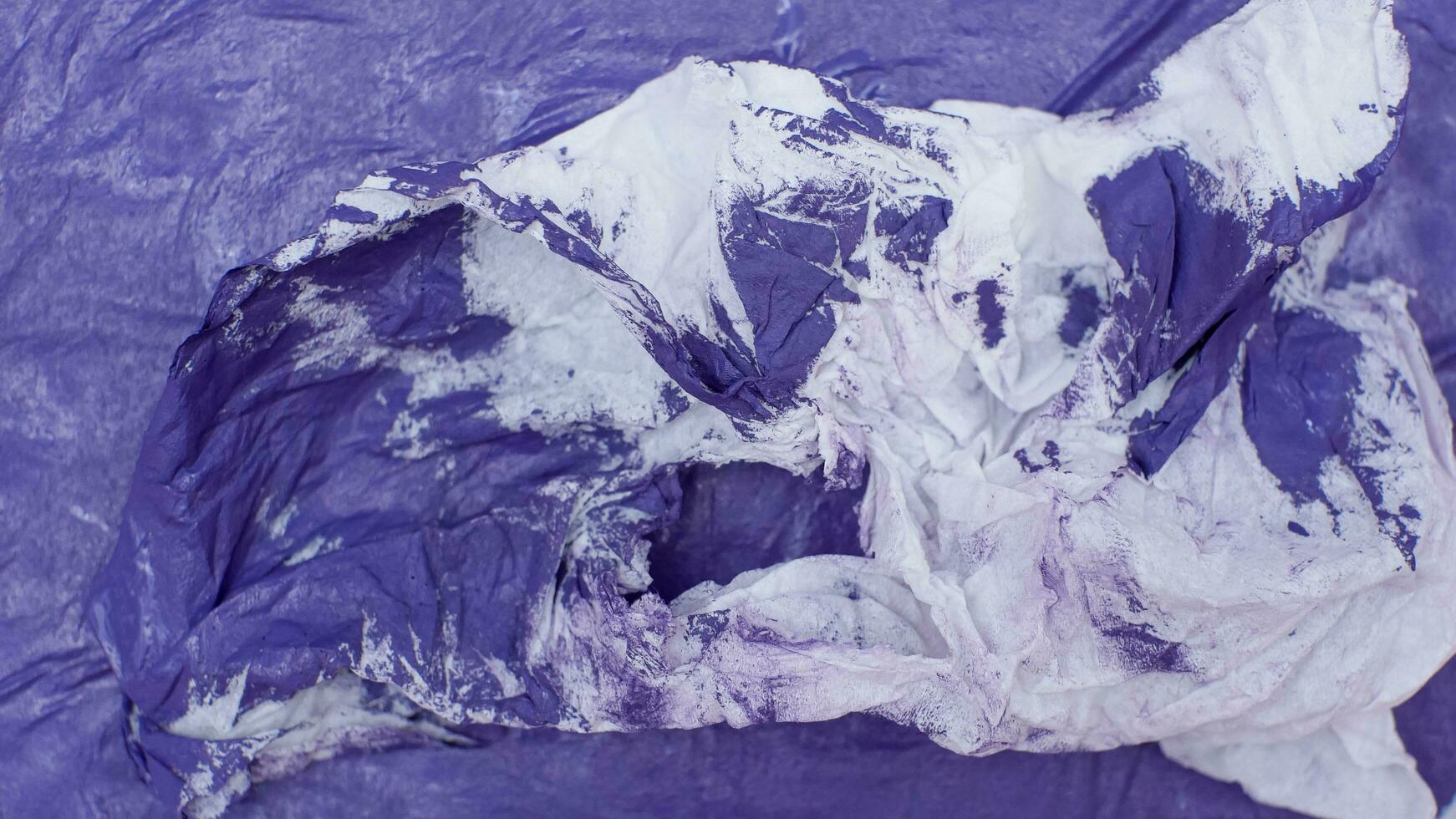 Torn and crumpled blue paper with white areas photo