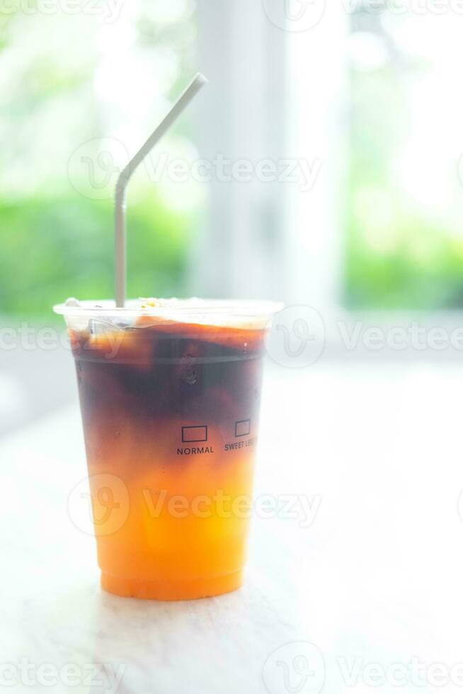 Refreshing drink with coffee and orange juice on white table photo