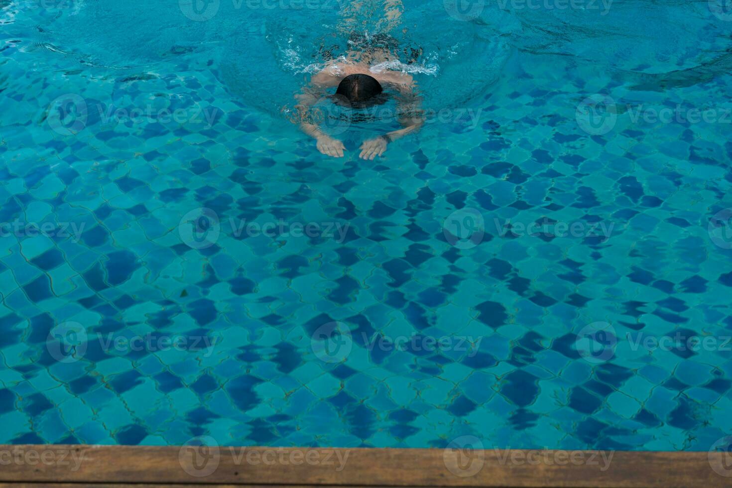 hombre nadar en el piscina a el hotel foto