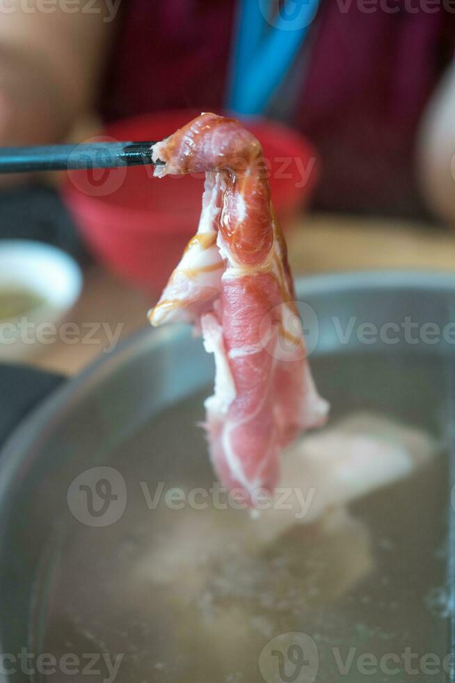 Hand holds marbled wagyu beef with chopstick. photo