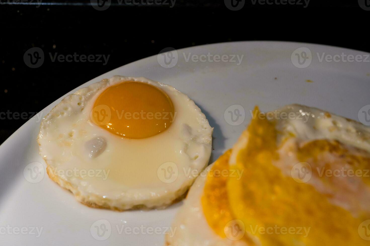 Fried egg or yolk on white dish for breakfast in the morning at hotel or resort. photo