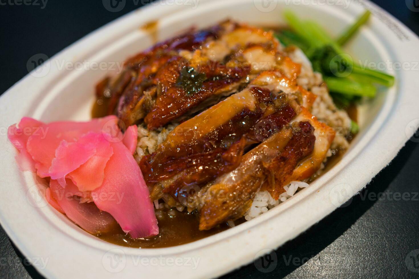 Roasted duck with gravy and rice on plate photo