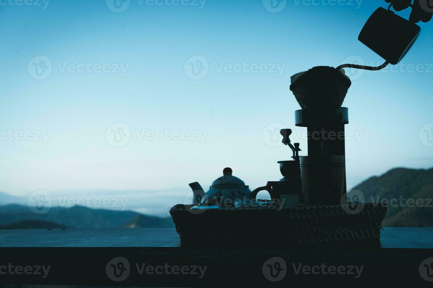 A woman making drip coffee with a beautiful mountain and nature view in background photo