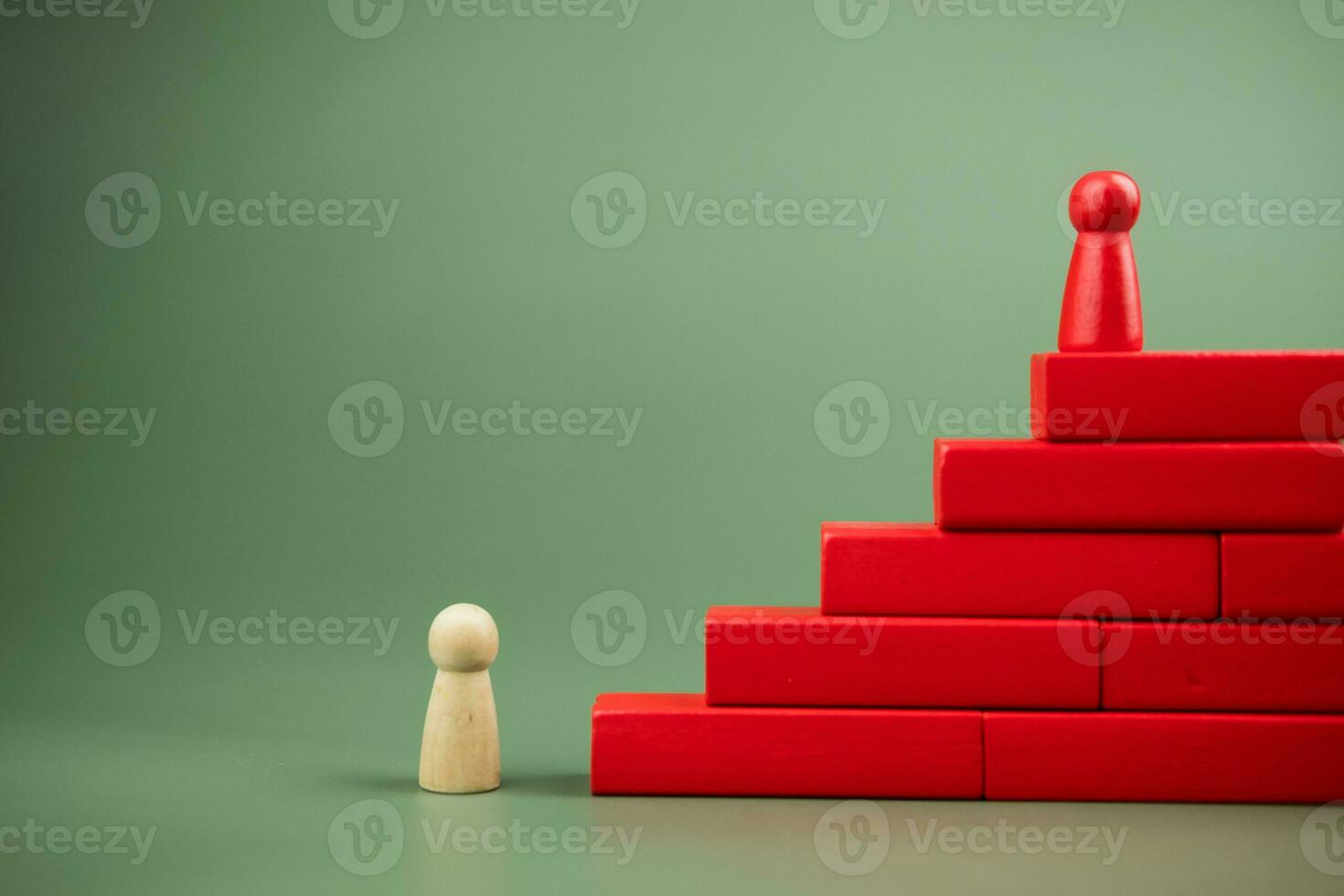 A wooden peg doll stands on the step, a metaphor for career advancement. photo