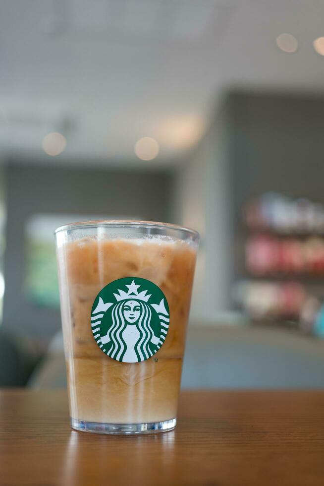 Bangkok, Thailand - January 9, 2024 Coffee refresher beverage served on crystal glass with Starbucks logo against coffee shop blur background. photo