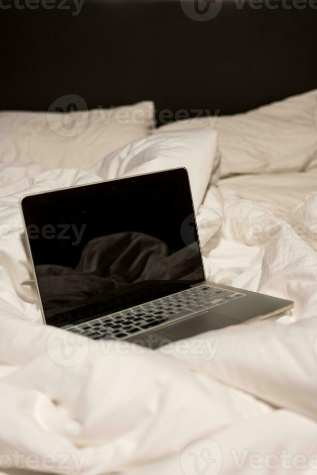 Laptop computer in bed with crumpled. photo