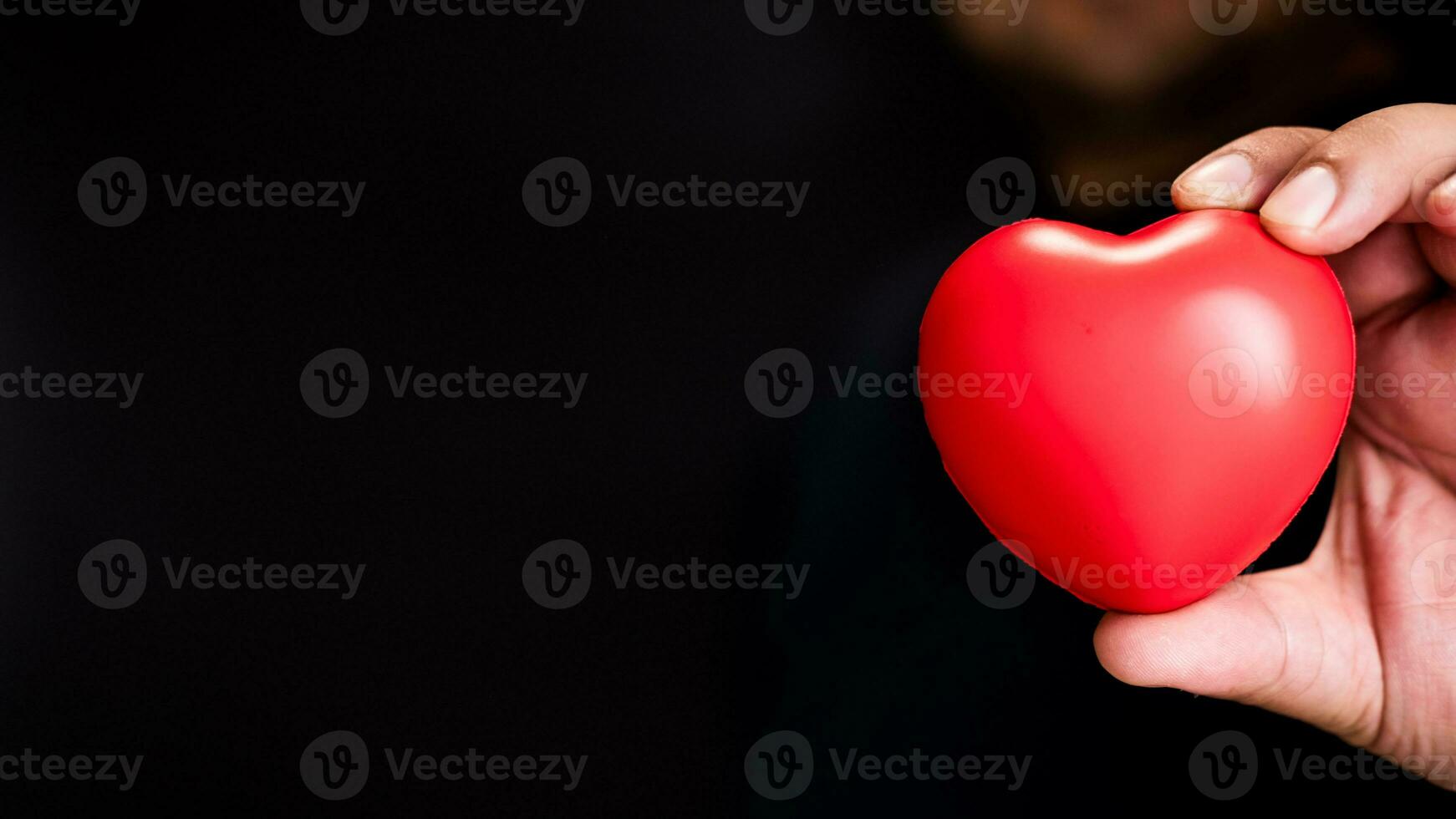 Red heart in man hands. Healthcare concept with copy space. photo