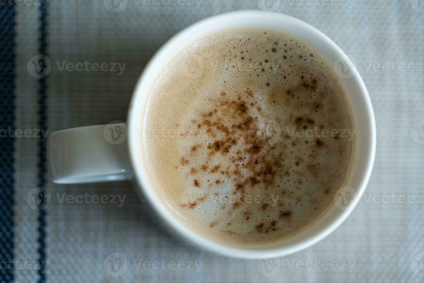 A hot cup of coffee from above in a white cup photo