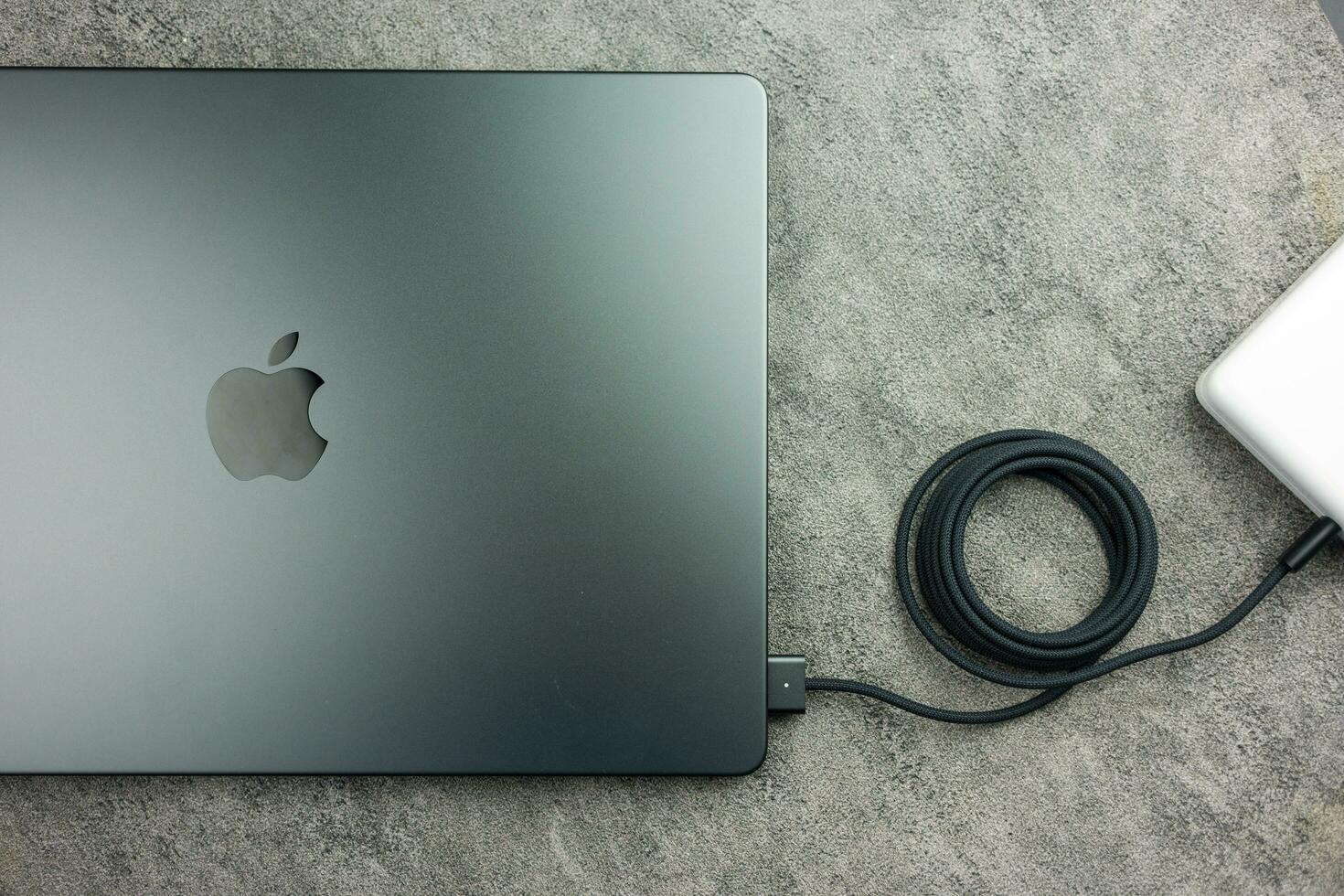 Bangkok, Thailand - January 7, 2024 A black braided USB-C cable charge and connect to Apple Macbook Pro with M3 Max photo