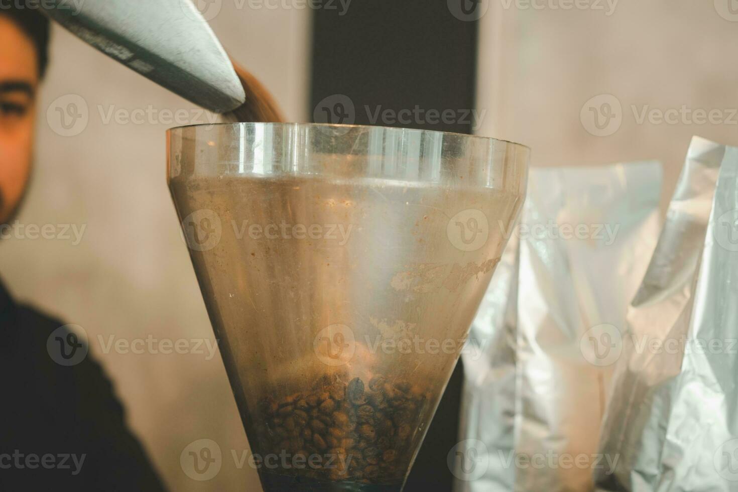 Process of pouring coffee beans into the grinder photo