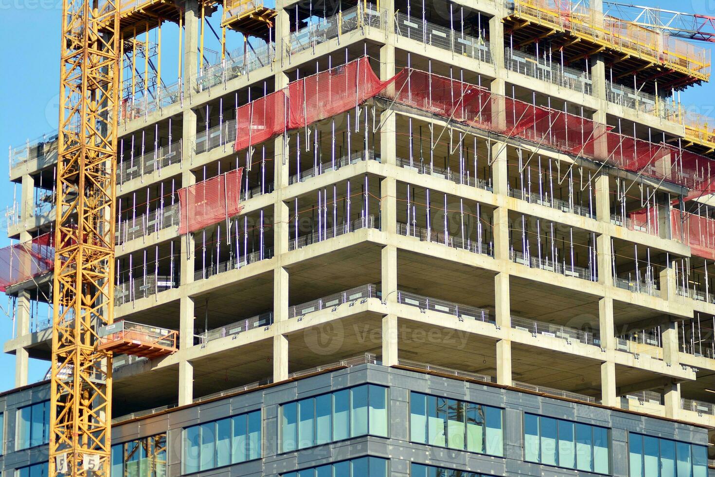 High rise building under construction. Installation of glass facade panels on a reinforced concrete structure. photo