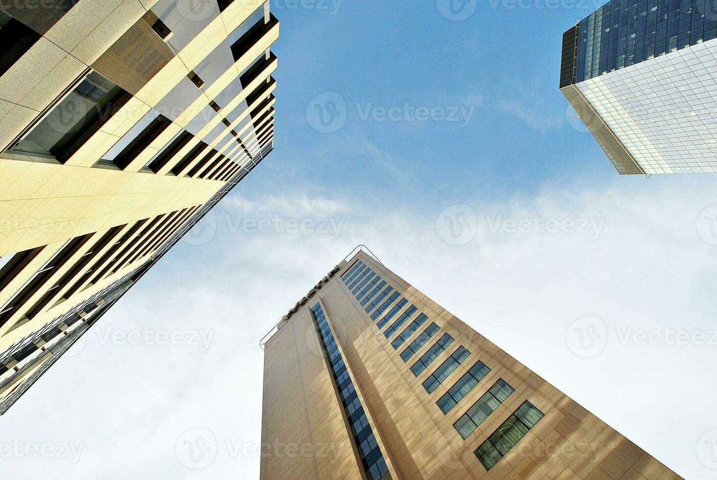 Abstract closeup of the glass-clad facade of a modern building covered in reflective plate glass. Architecture abstract background. Glass wall and facade detail. photo