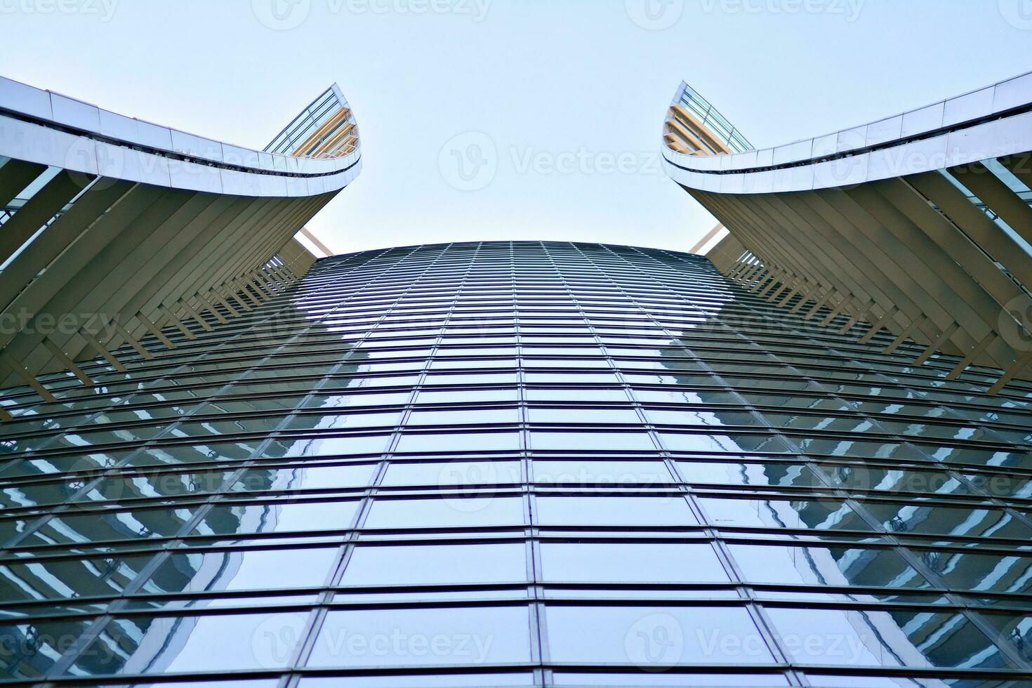 Glass building with transparent facade of the building and blue sky. Structural glass wall reflecting blue sky. Abstract modern architecture fragment. Contemporary architectural background. photo