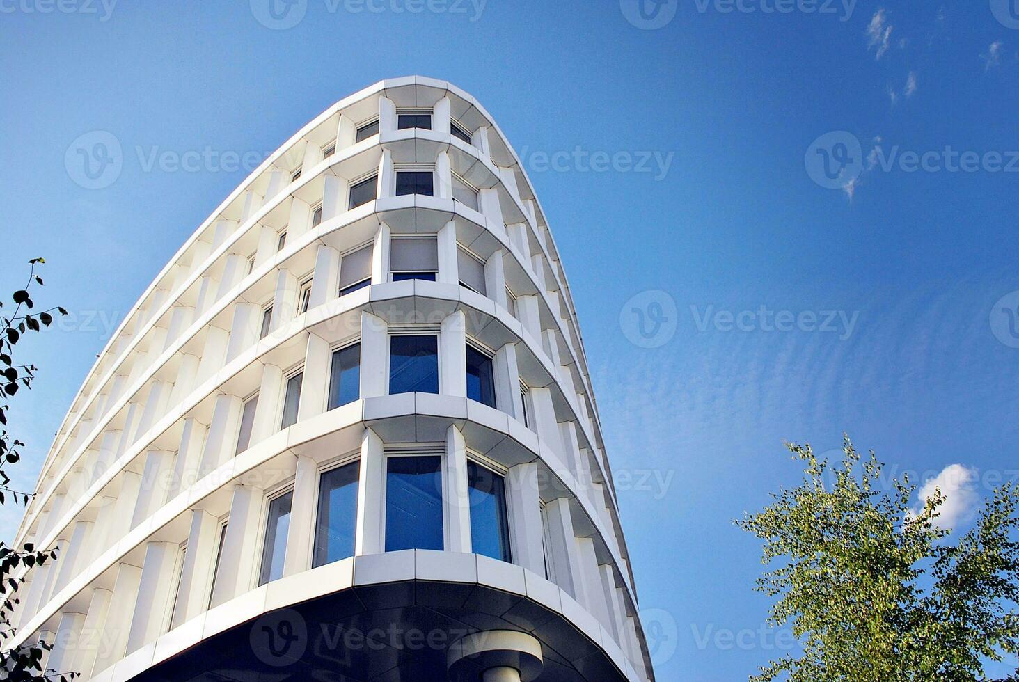 Abstract closeup of the glass-clad facade of a modern building covered in reflective plate glass. Architecture abstract background. Glass wall and facade detail. photo