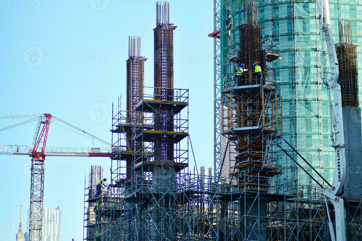 High rise building under construction. Installation of glass facade panels on a reinforced concrete structure. photo