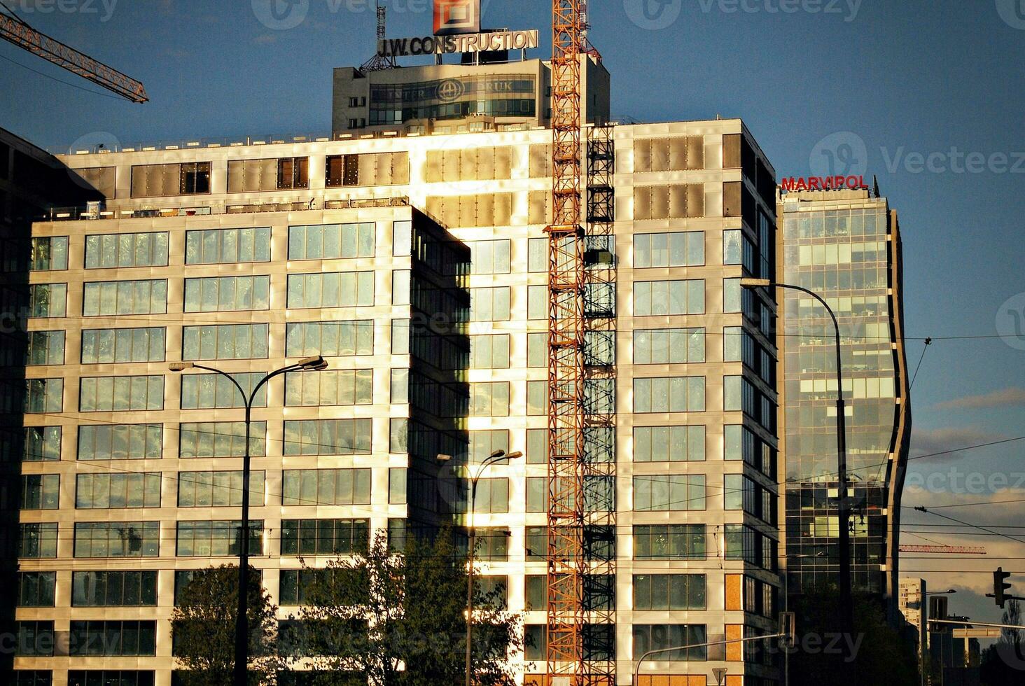 High rise building under construction. Installation of glass facade panels on a reinforced concrete structure. photo