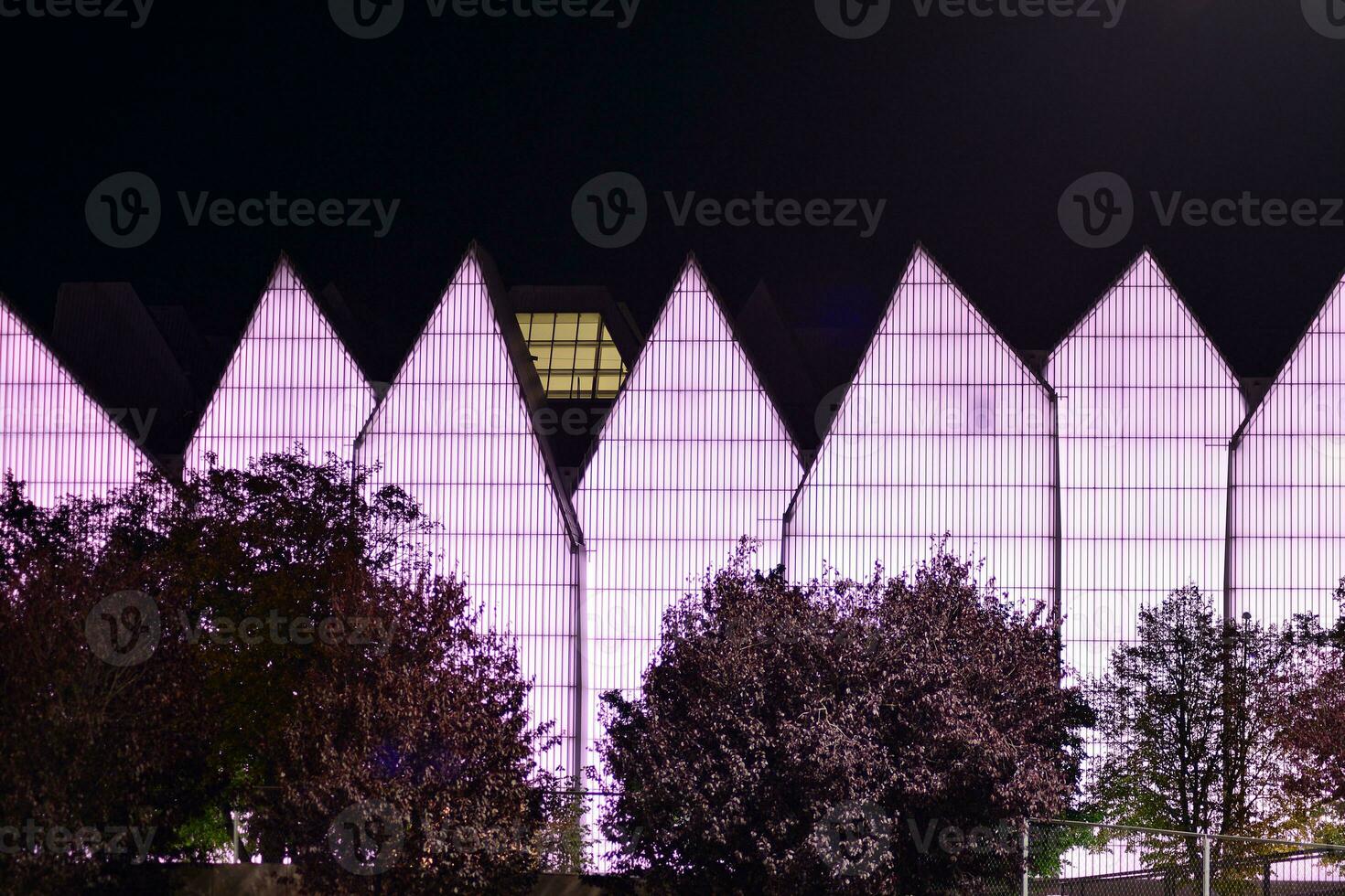 Pattern of office buildings windows illuminated at night. Glass architecture ,corporate building at night - business concept. photo
