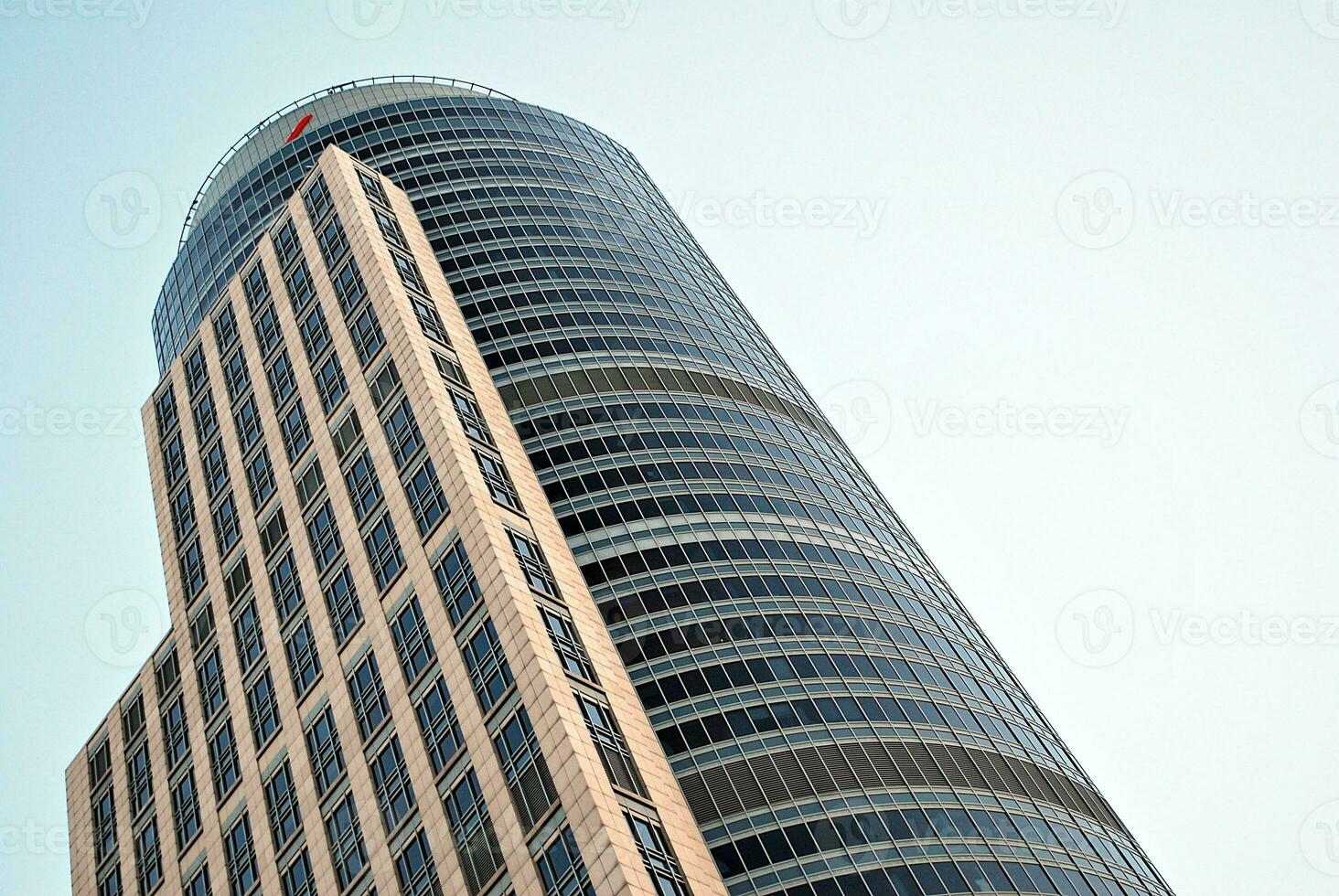 Abstract closeup of the glass-clad facade of a modern building covered in reflective plate glass. Architecture abstract background. Glass wall and facade detail. photo