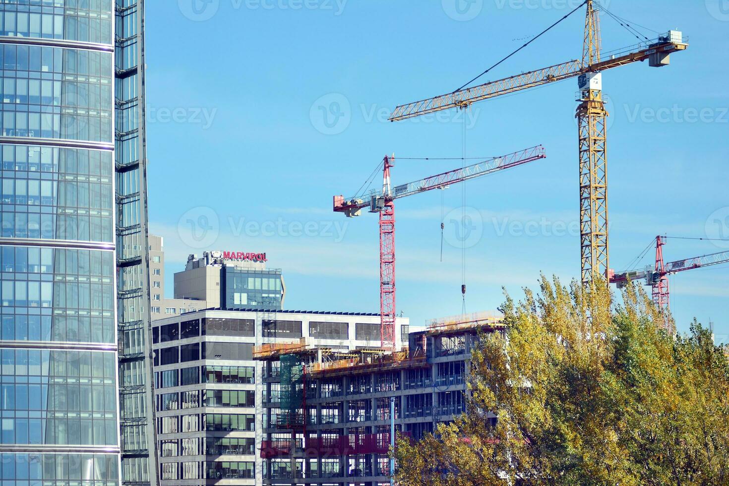 High rise building under construction. Installation of glass facade panels on a reinforced concrete structure. photo