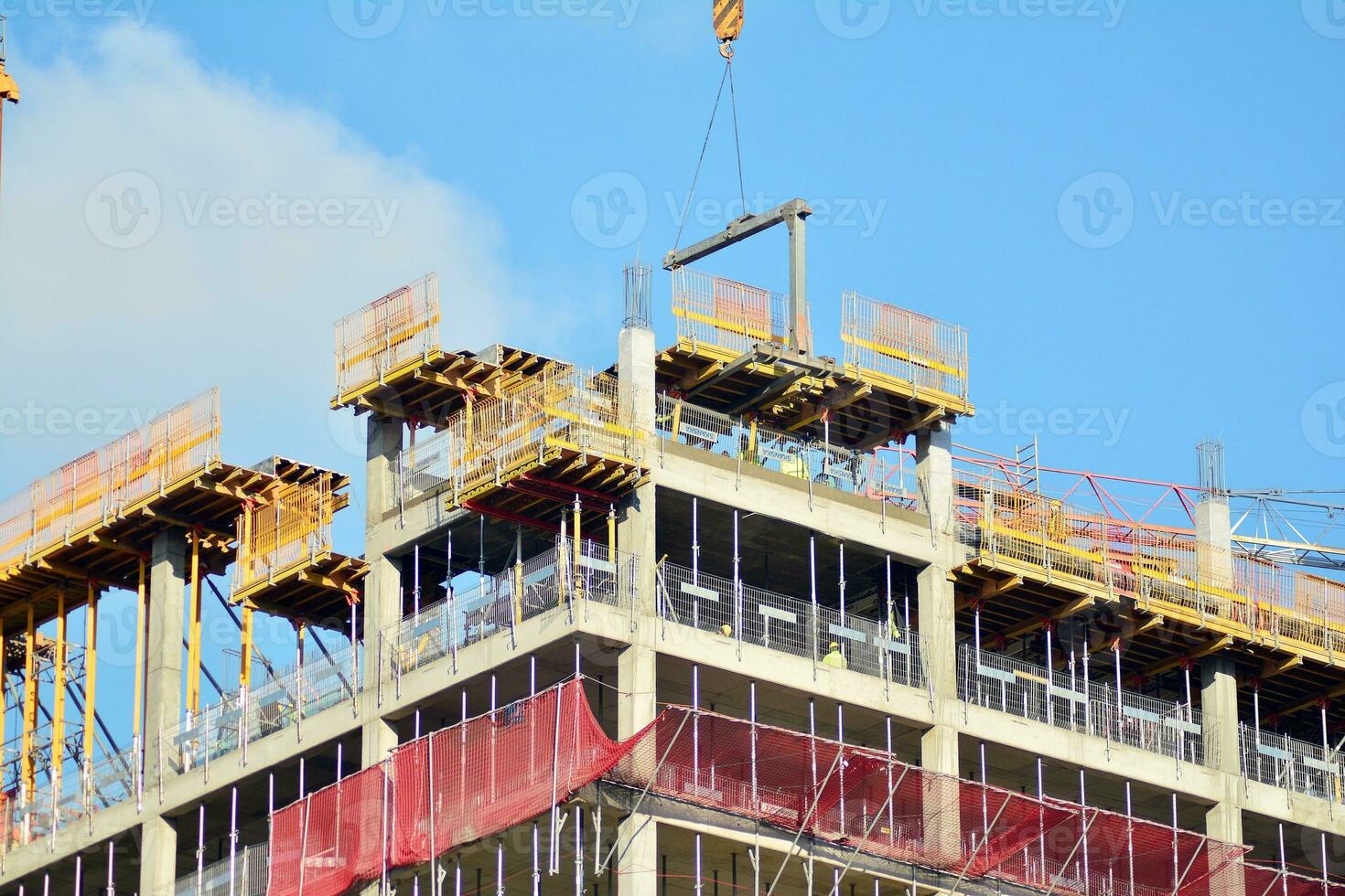 High rise building under construction. Installation of glass facade panels on a reinforced concrete structure. photo