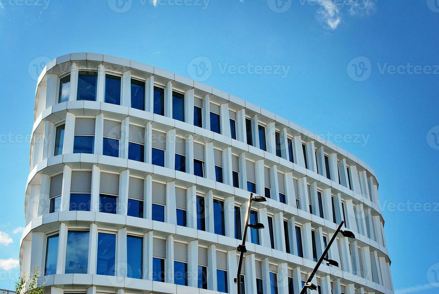 Abstract closeup of the glass-clad facade of a modern building covered in reflective plate glass. Architecture abstract background. Glass wall and facade detail. photo