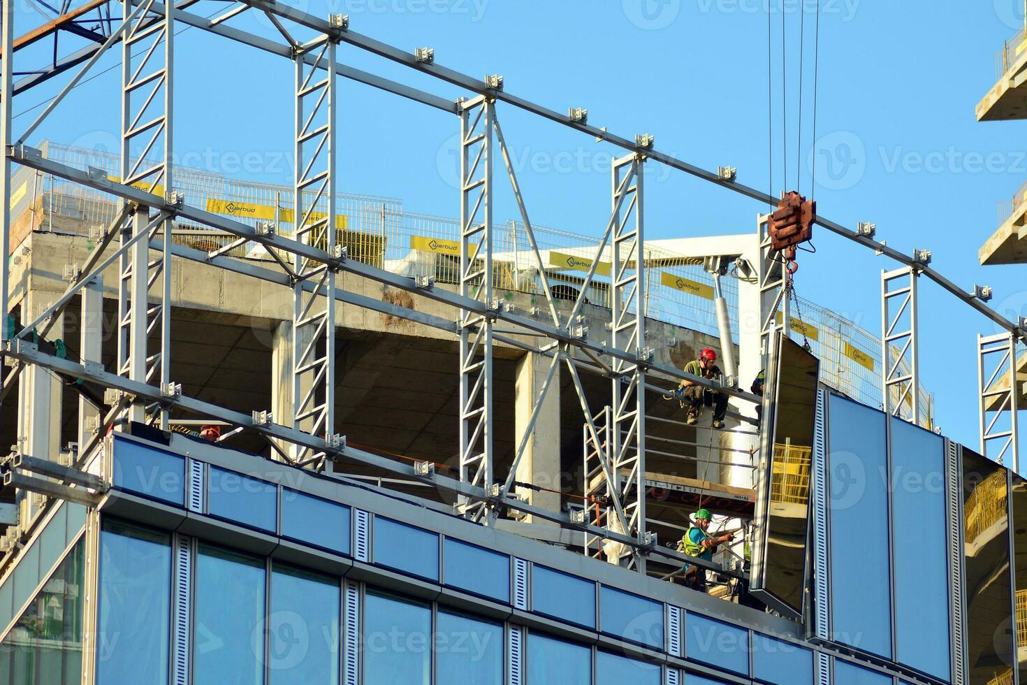 High rise building under construction. Installation of glass facade panels on a reinforced concrete structure. photo