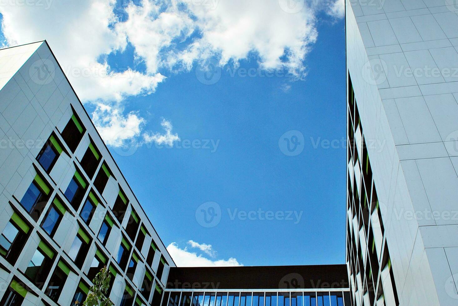 Abstract closeup of the glass-clad facade of a modern building covered in reflective plate glass. Architecture abstract background. Glass wall and facade detail. photo