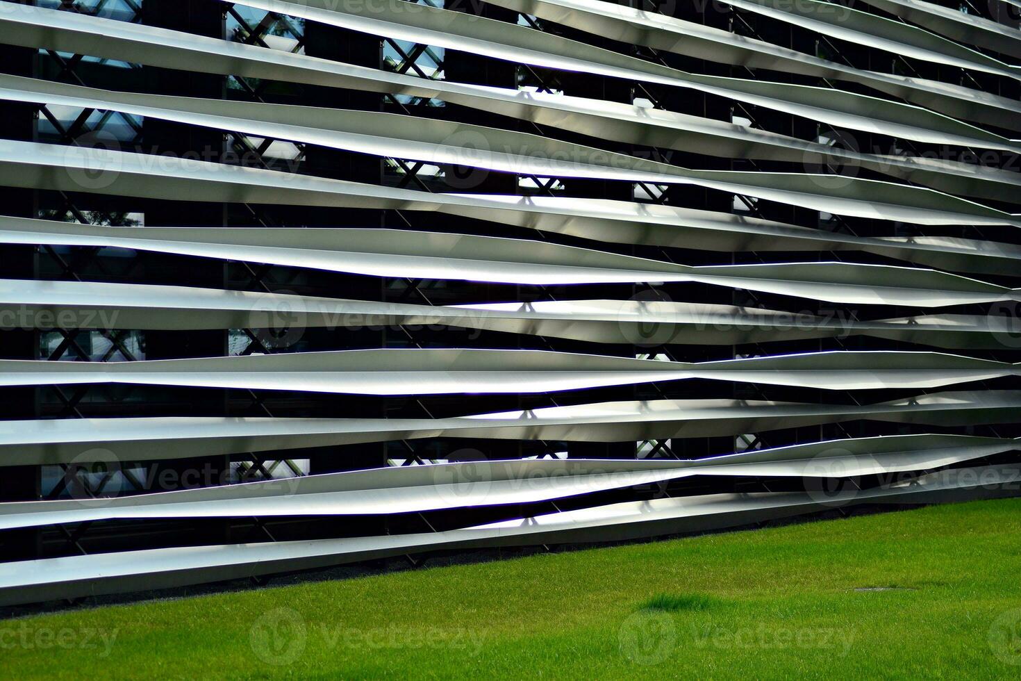 Abstract closeup of the glass-clad facade of a modern building covered in reflective plate glass. Architecture abstract background. Glass wall and facade detail. photo