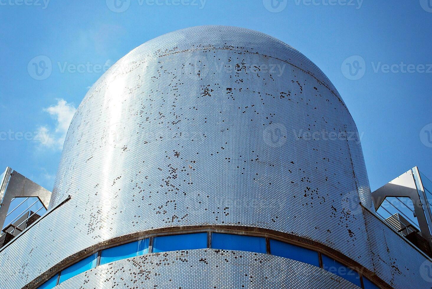 Abstract closeup of the glass-clad facade of a modern building covered in reflective plate glass. Architecture abstract background. Glass wall and facade detail. photo