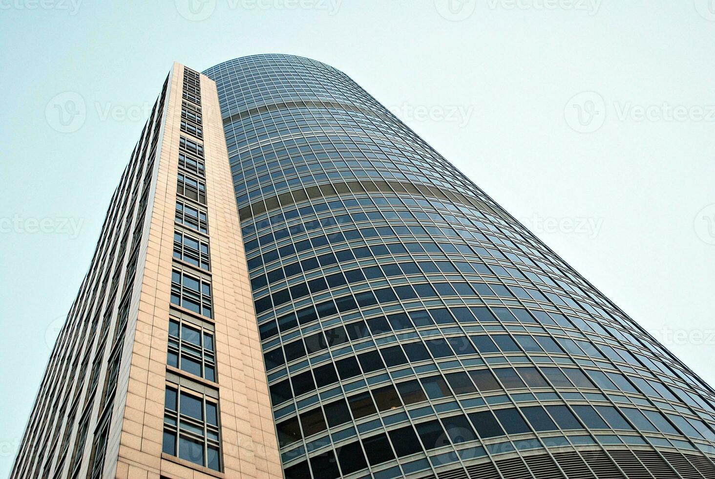 Abstract closeup of the glass-clad facade of a modern building covered in reflective plate glass. Architecture abstract background. Glass wall and facade detail. photo