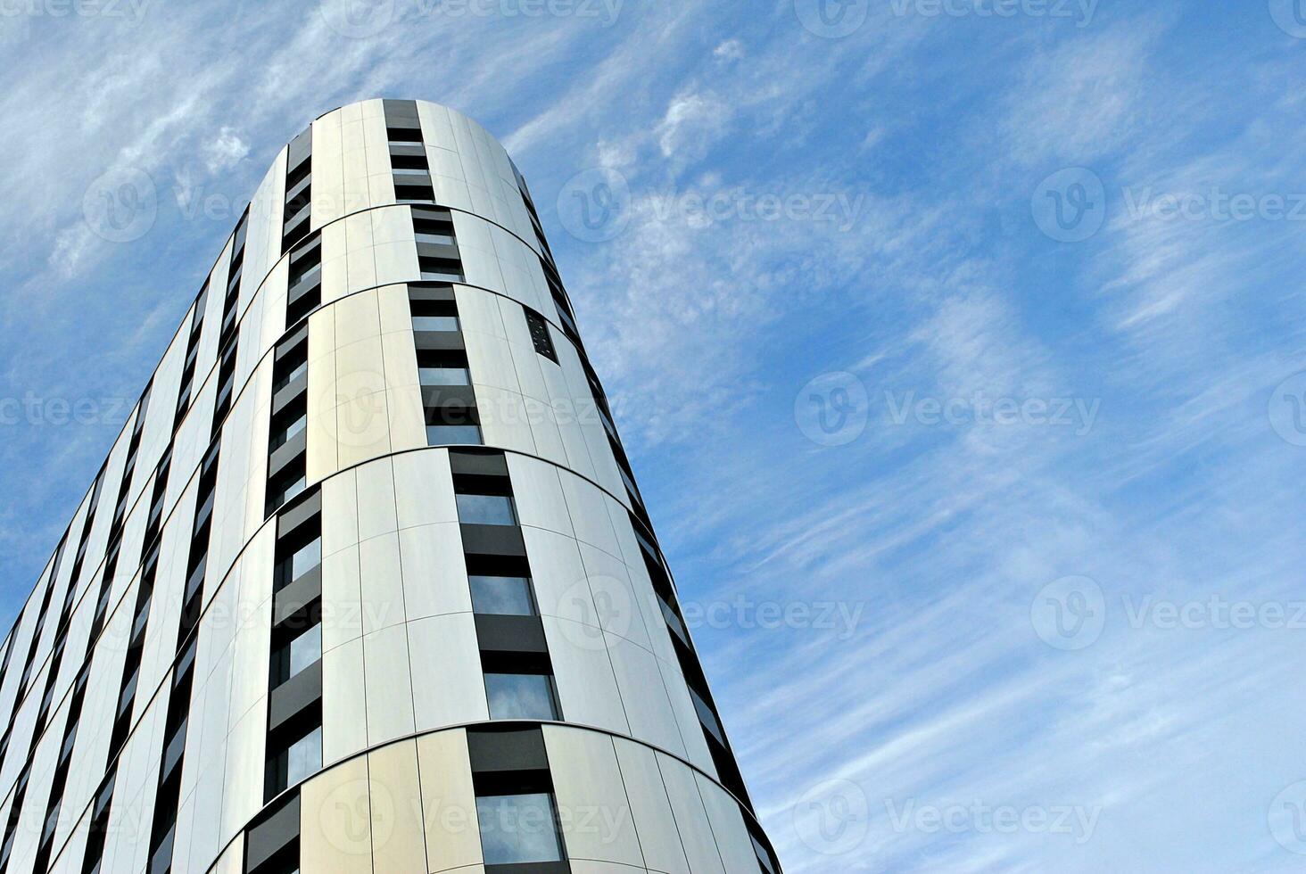 Abstract closeup of the glass-clad facade of a modern building covered in reflective plate glass. Architecture abstract background. Glass wall and facade detail. photo