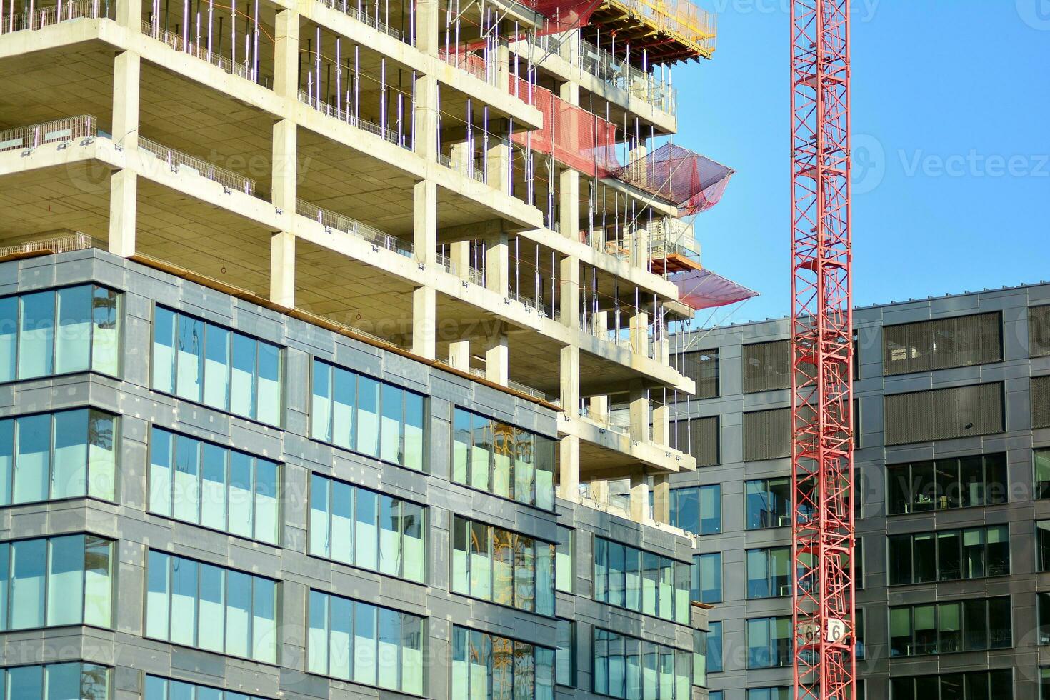 High rise building under construction. Installation of glass facade panels on a reinforced concrete structure. photo