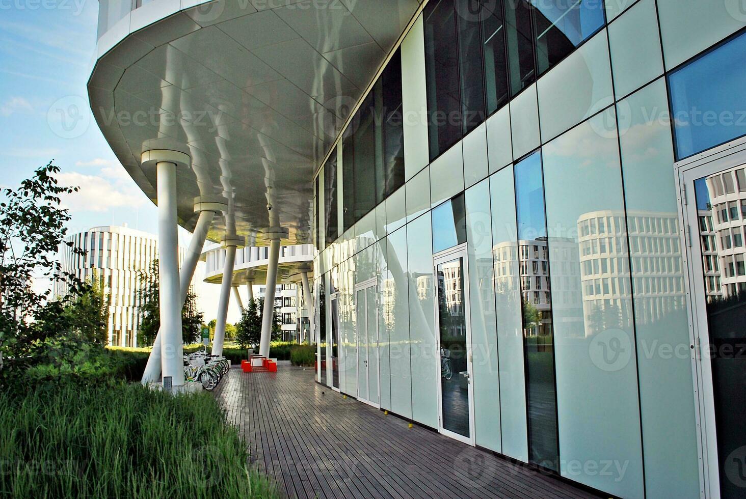 Abstract closeup of the glass-clad facade of a modern building covered in reflective plate glass. Architecture abstract background. Glass wall and facade detail. photo