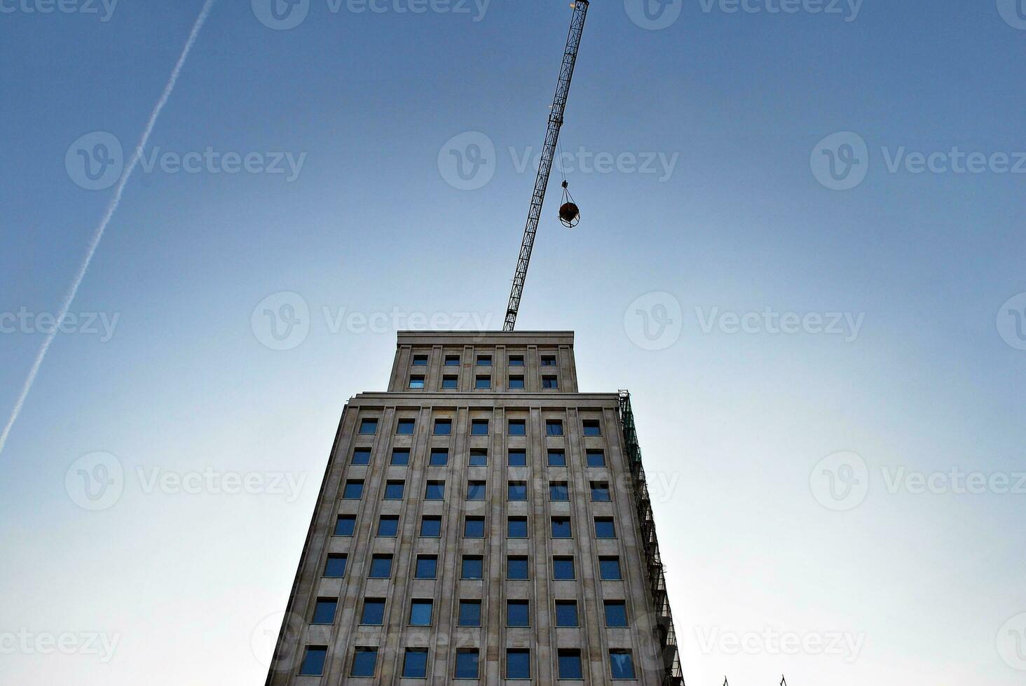 High rise building under construction. Installation of glass facade panels on a reinforced concrete structure. photo