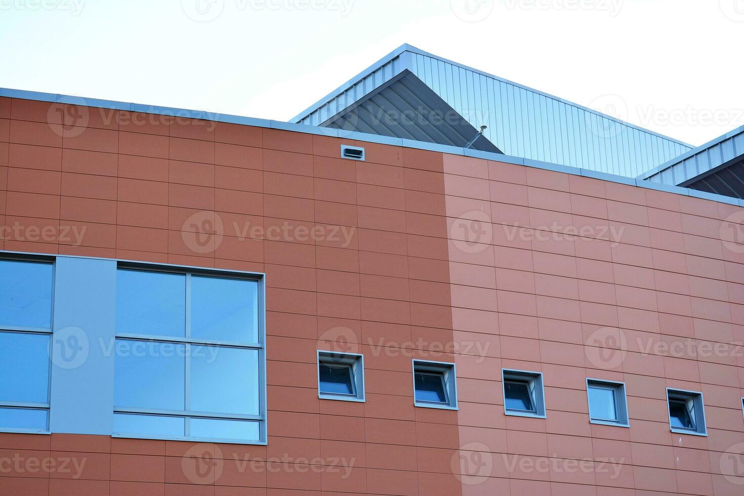 Abstract closeup of the glass-clad facade of a modern building covered in reflective plate glass. Architecture abstract background. Glass wall and facade detail. photo