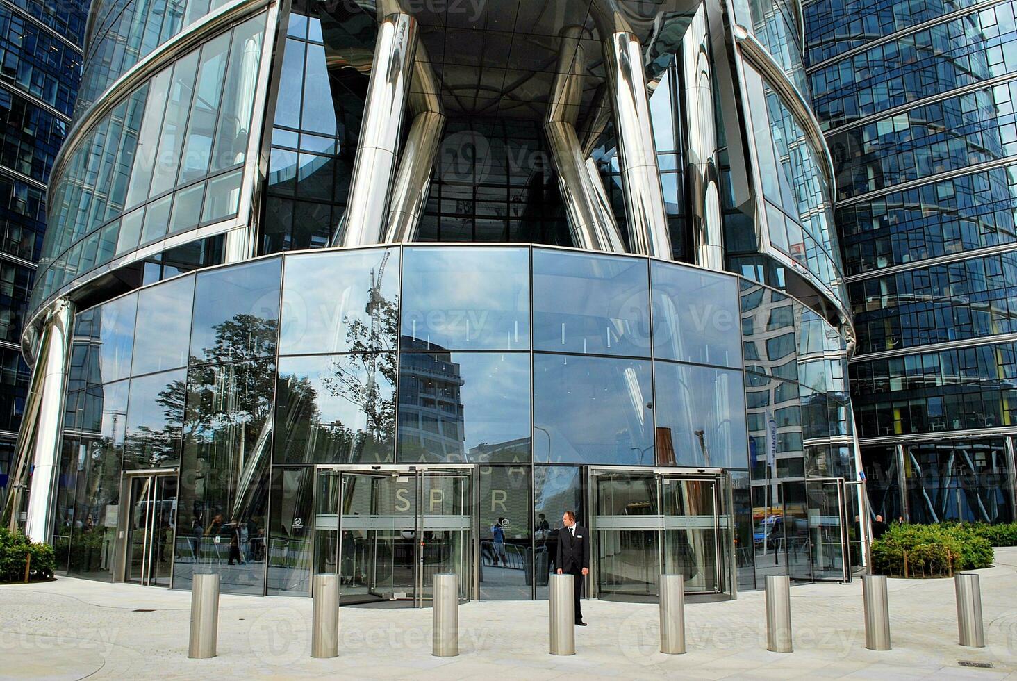 Glass building with transparent facade of the building and blue sky. Structural glass wall reflecting blue sky. Abstract modern architecture fragment. Contemporary architectural background. photo